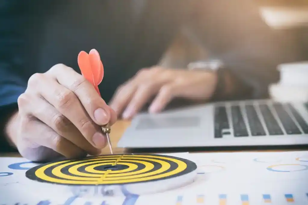 a person is holding a dart in a center of dart board