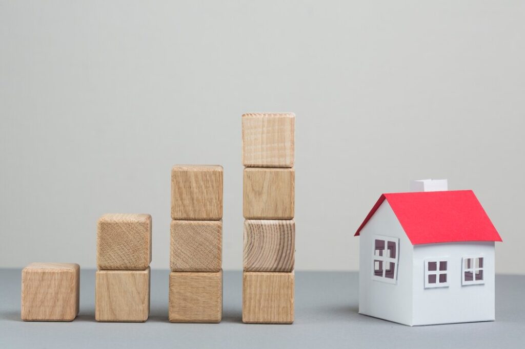 A toy house next to a stack of wooden blocks