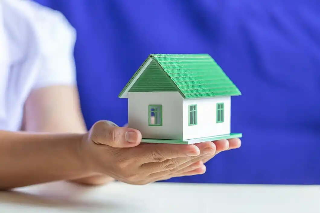 Human hands holding model of dream house